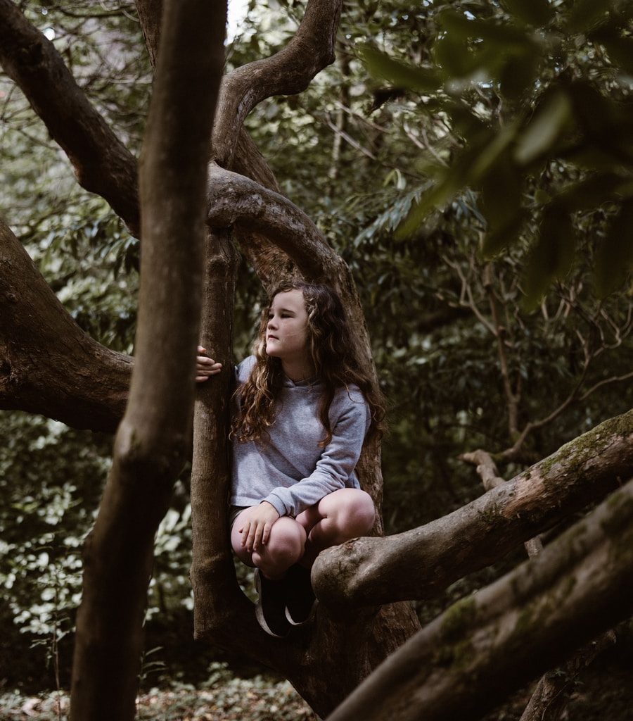 girl sitting on tree branch
