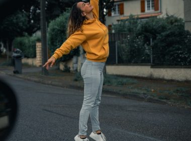 woman in yellow jacket and white pants walking on the street during daytime