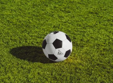 white and black soccer ball on grass field