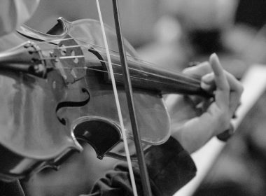 person playing violin in grayscale photography