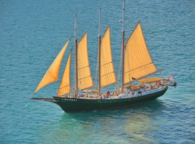 a sailboat with yellow sails in the ocean