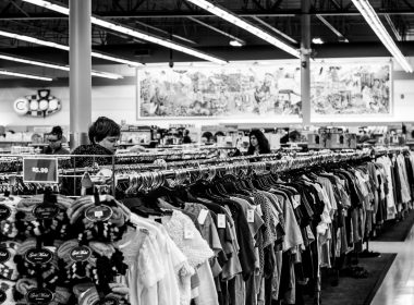 grayscale photography of people inside a clothing shop